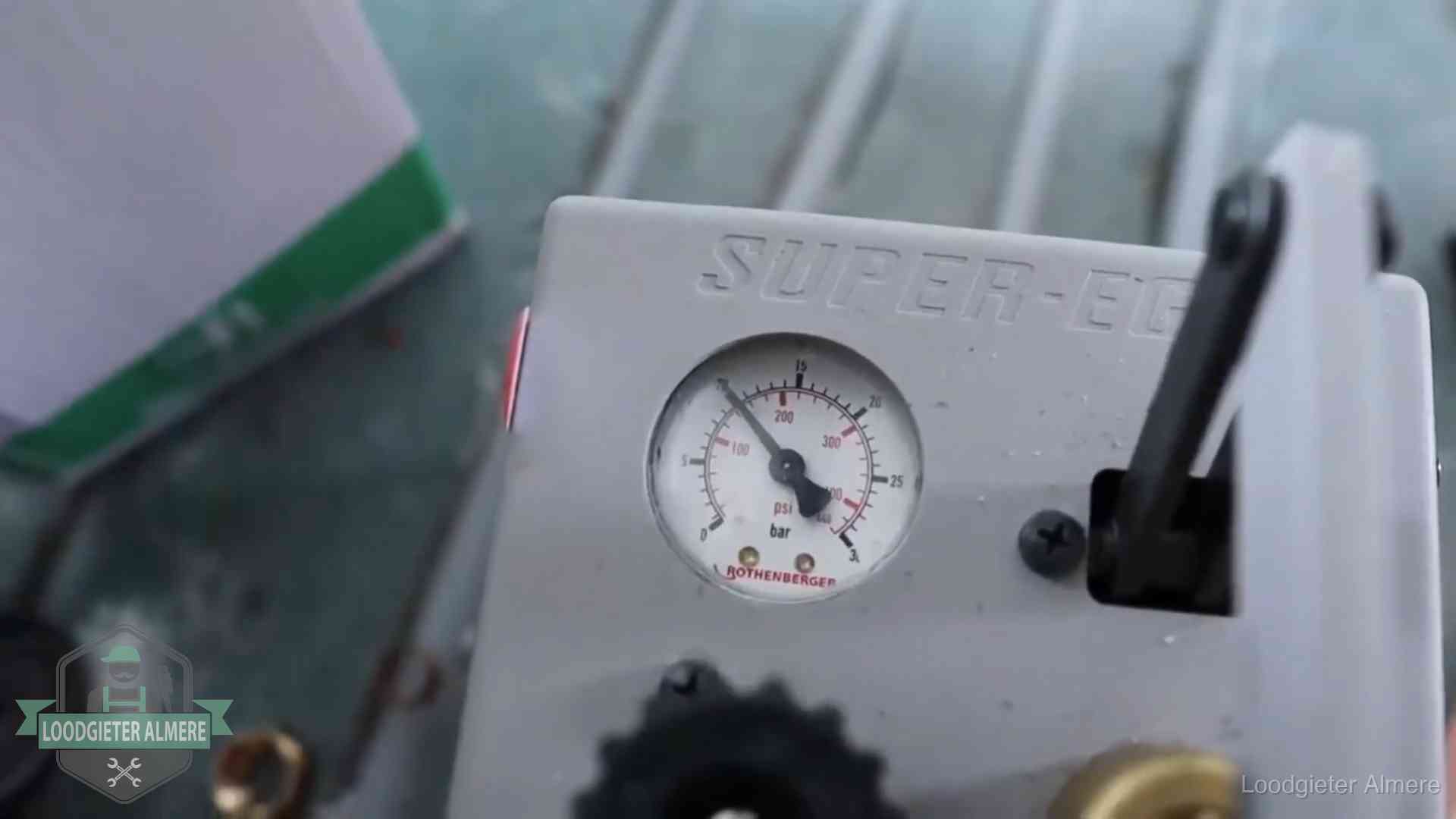 Manometer van een afperspomp bij controle van nieuw leidingwerk in Almere