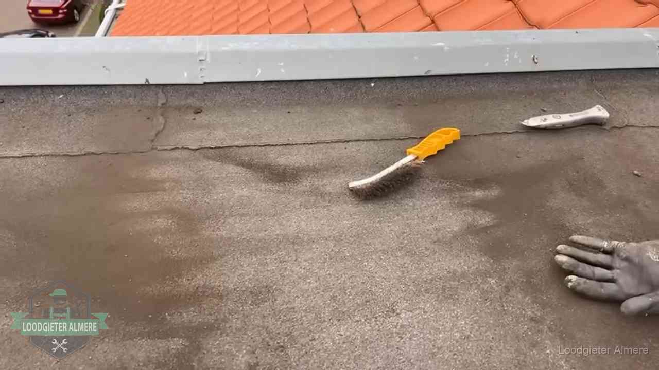 Kosten van daklekkage-reparatie in Almere Dakdekker bereidt een bitumen plat dak voor op reparatie bij de daktrim in Almere