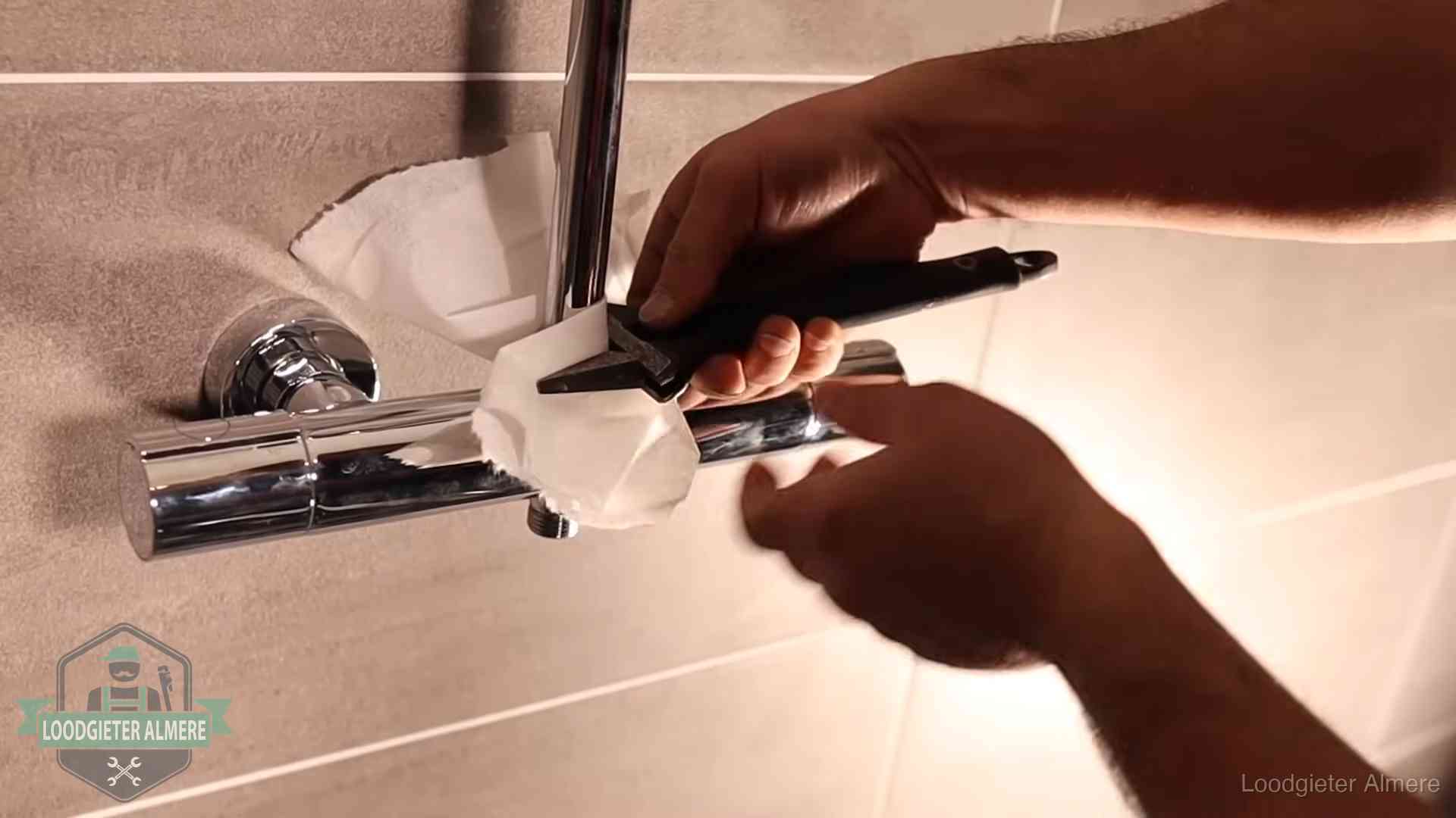 Loodgieter monteert een douchekraan met bescherming tegen krassen in Almere