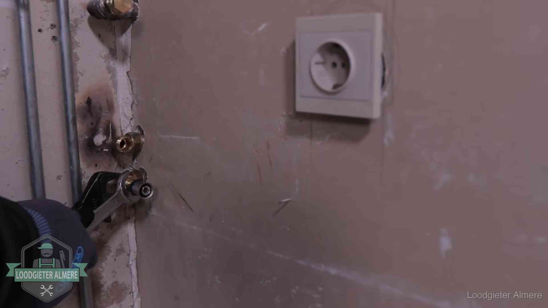Monteur draait een perskoppeling vast op een leidingaansluiting in Almere