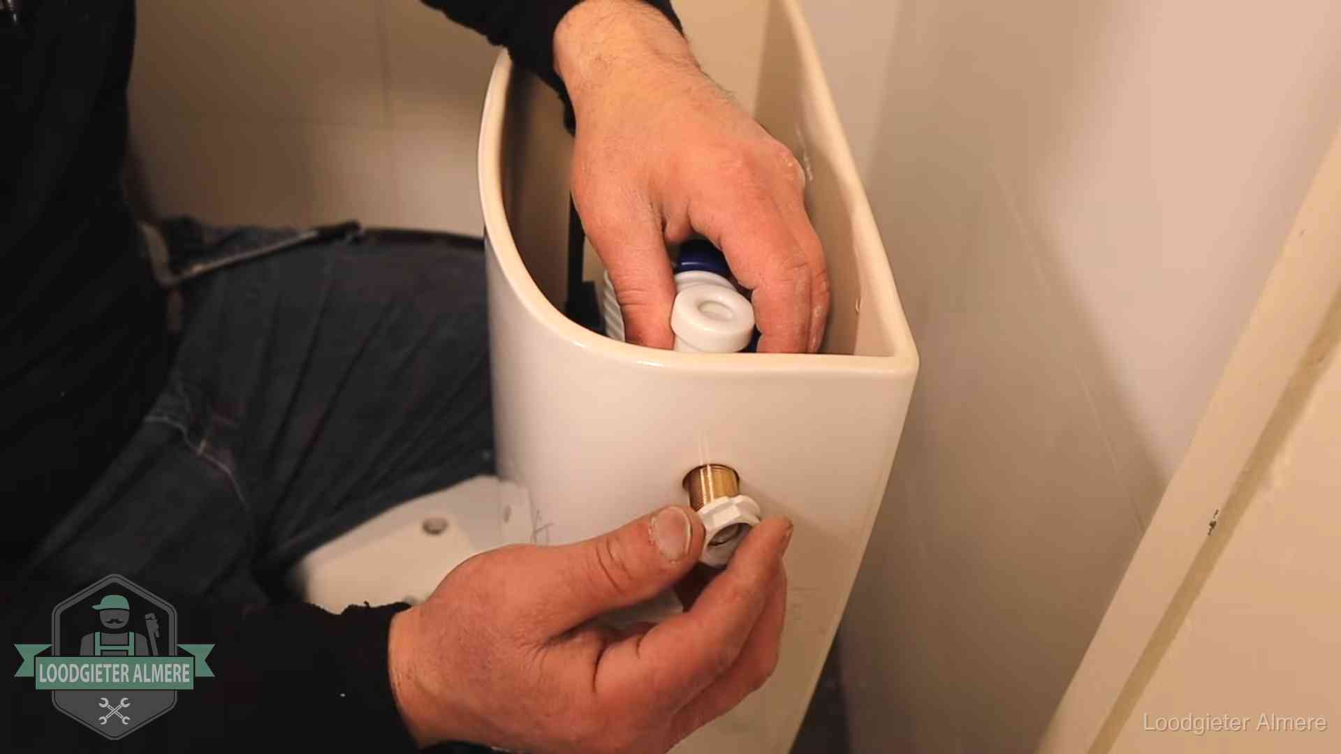 Loodgieter voor je verstopte wc in Almere Loodgieter monteert de vlotterkraan van een stortbak bij een toilet in Almere
