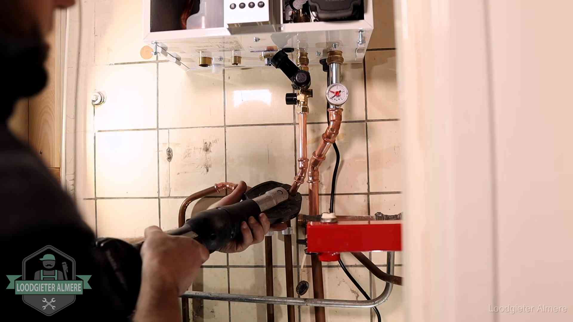 Cv-ketel onderhoud in Almere Monteur werkt aan de leidingen onder een cv-ketel in Almere