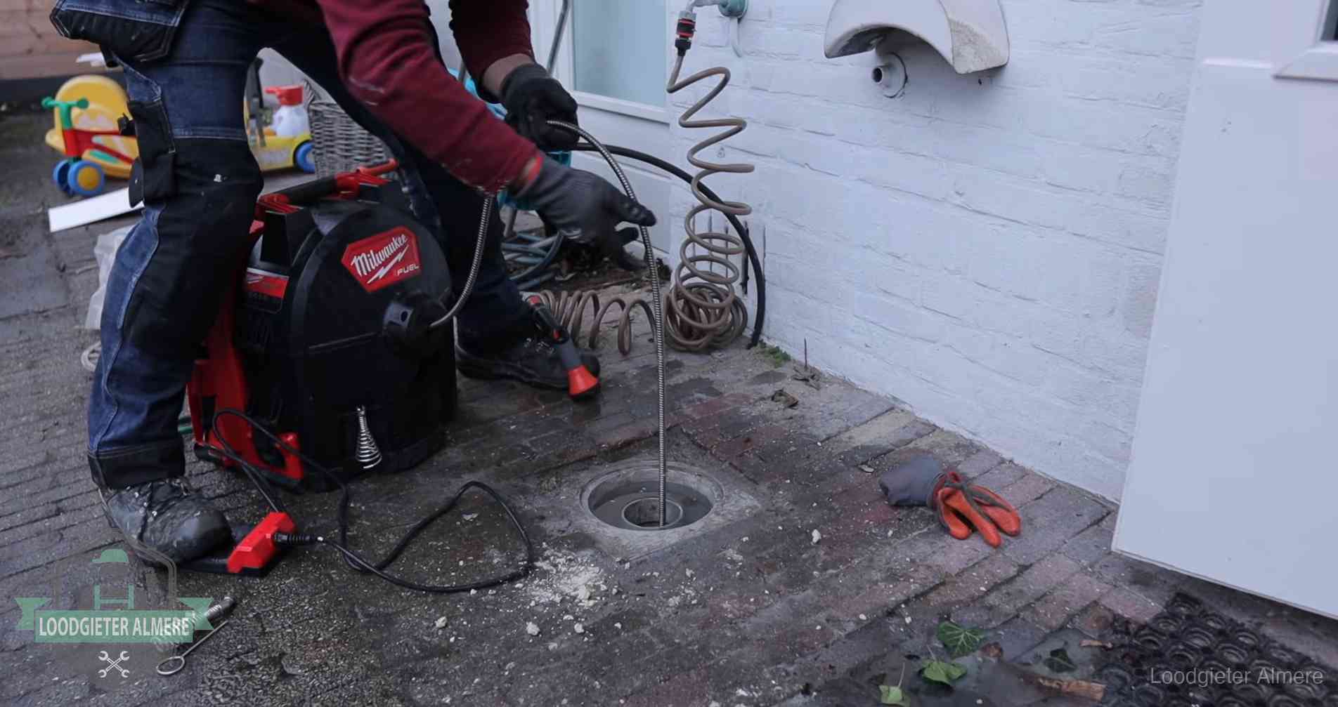 Ontstoppingsputje in de bestrating naast de gevel van een woning in Almere