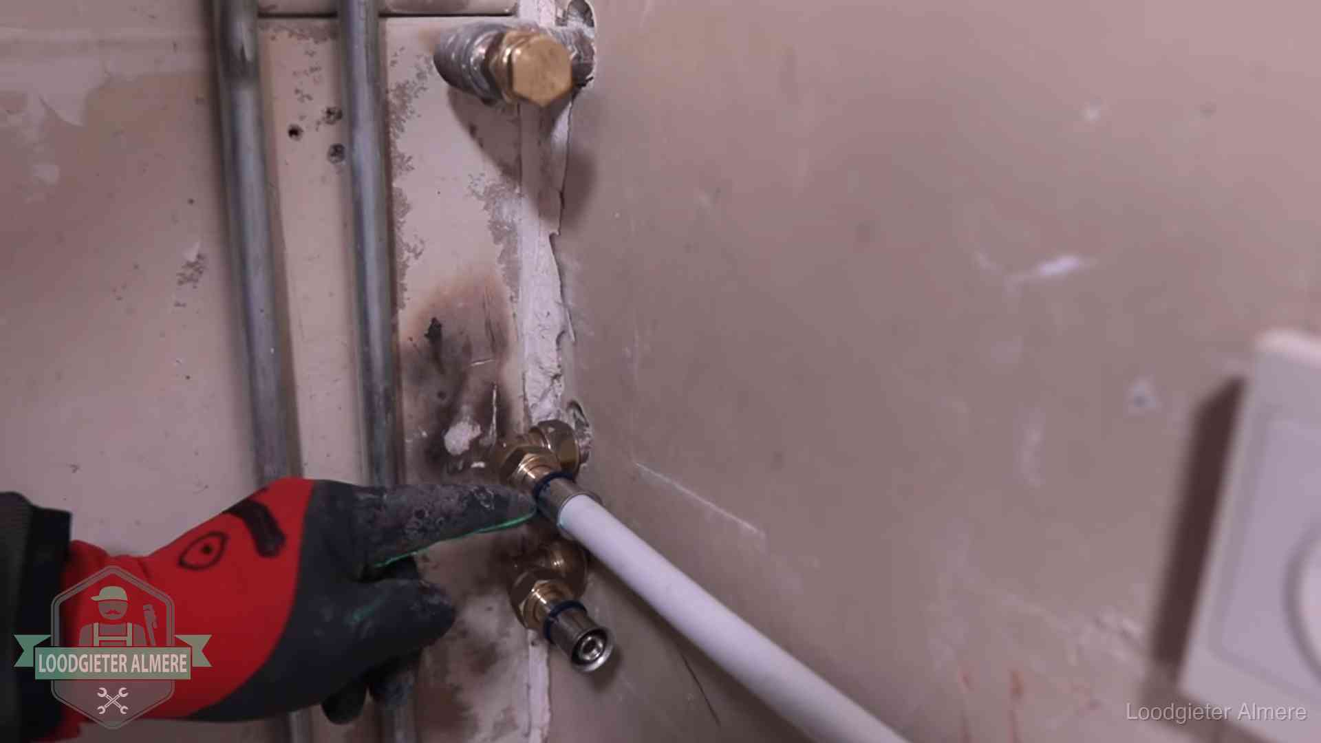 Loodgieter wijst de persfitting op nieuwe muuraansluitingen aan in een woning in Almere
