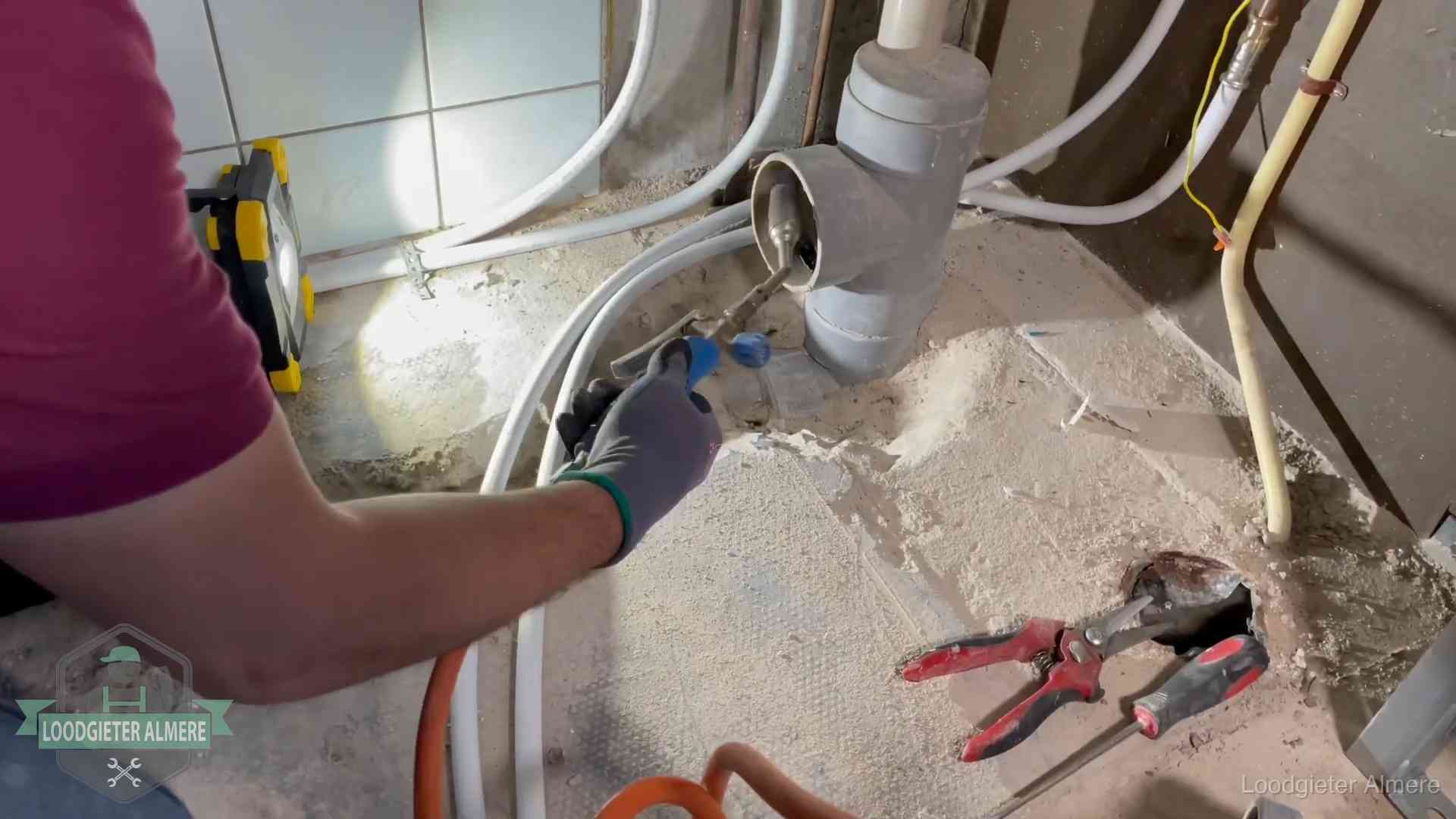 Loodgieter werkt aan leidingen bij een pvc-standleiding in een appartement in Almere