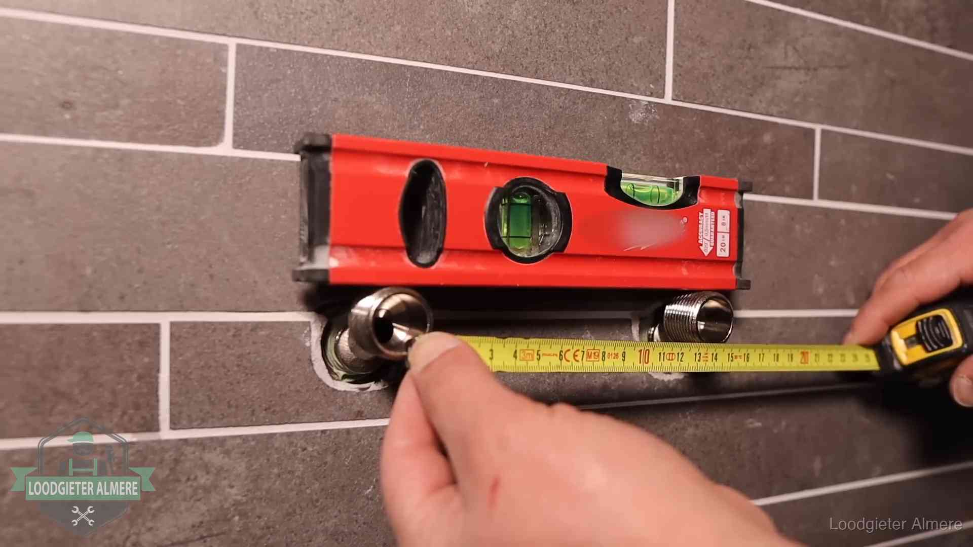 Waterpas en duimstok bij kraan-aansluitpunten in een badkamer in Almere
