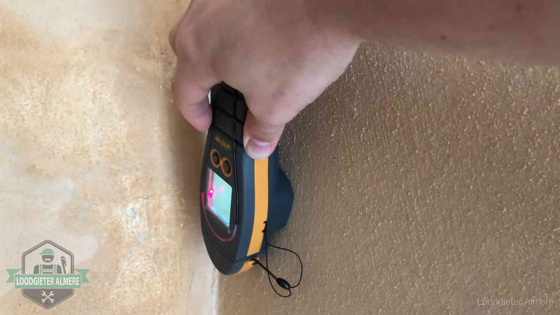 Daklekkage opsporen zonder hakwerk in Almere Vochtmeter tegen een muur met vochtplekken tijdens het opsporen van een daklekkage in Almere