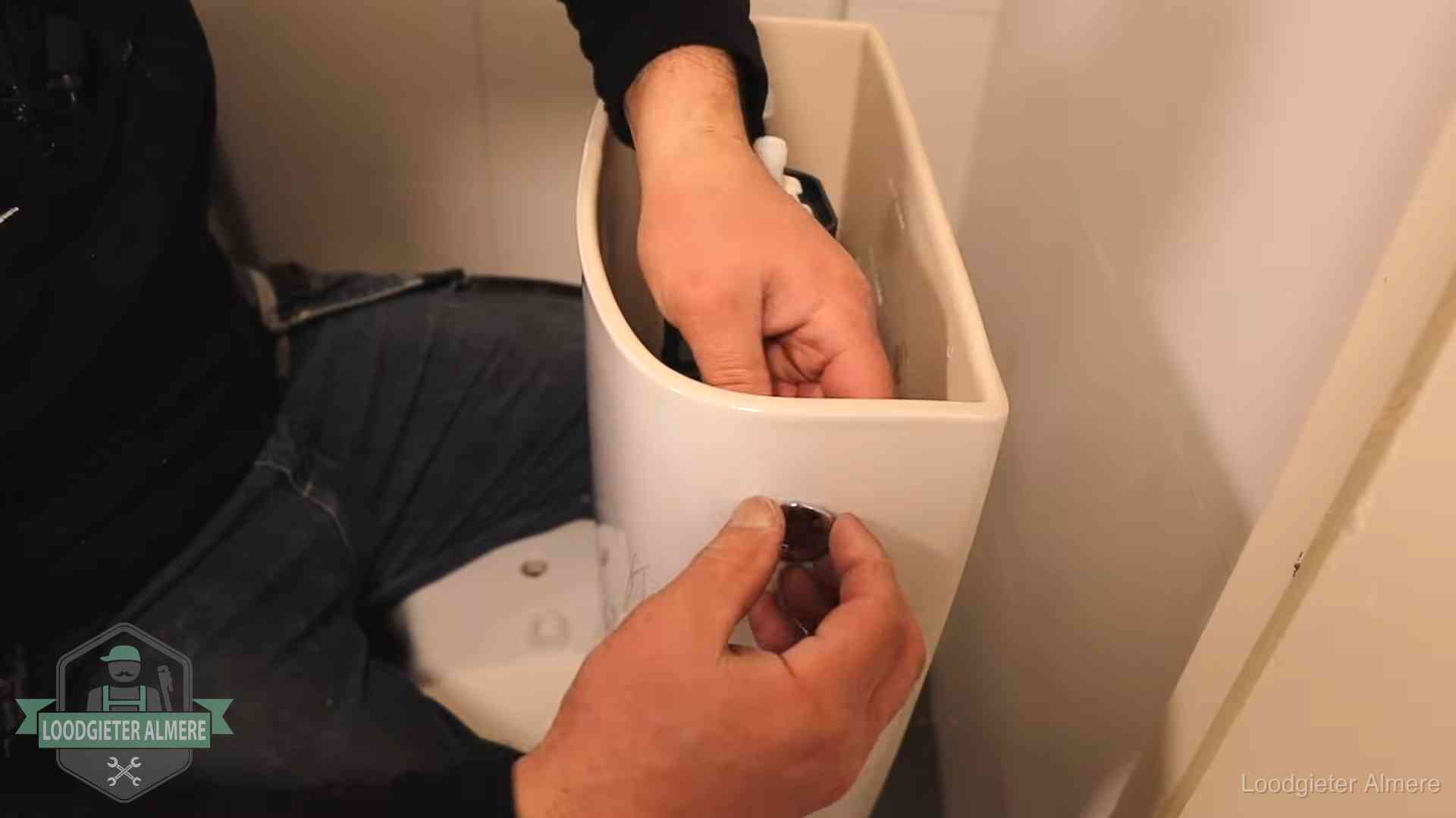 Je wc verstoppingsvrij houden in Almere Drukknop van een duoblok-stortbak wordt gemonteerd bij een toilet in Almere